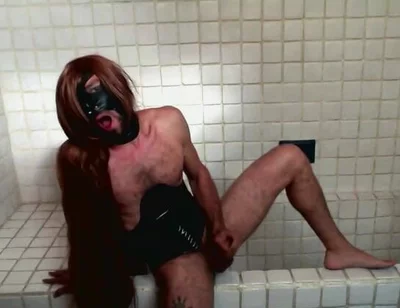Long Hair Sissy in Corset Uses Gagball in Bathroom