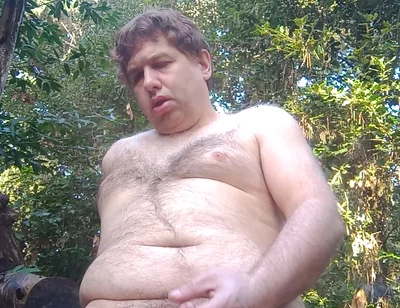 Boy in the woods sitting on a tree trunk pees and then jerks off with saliva coming from his mouth at the end