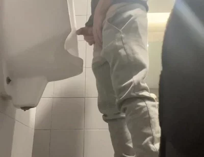 2 Boys in Sneakers Having Fun at Public Toilets' Urinal