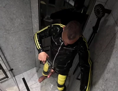 Rubber Man Pisses with Uncut Cock